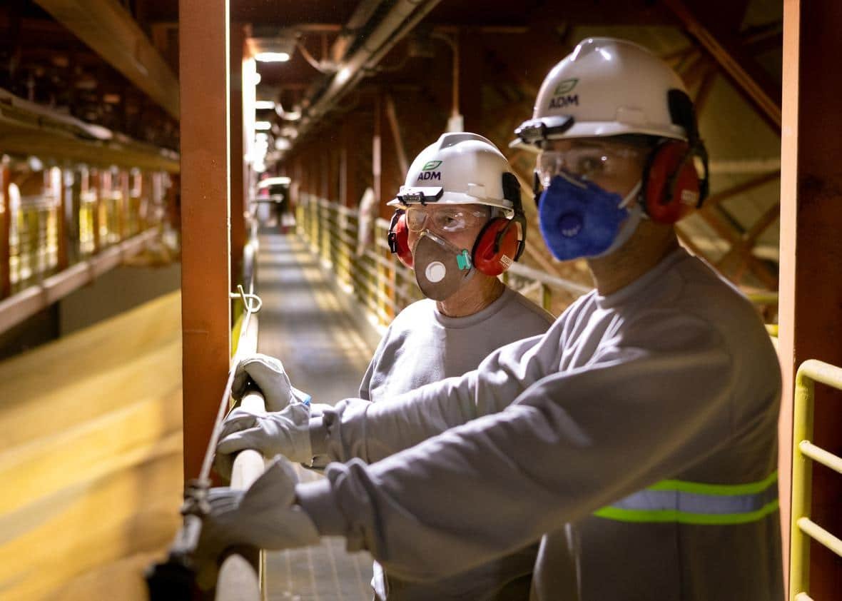 two-men-with-hard-hats-and-respirators-standing-inside-loading-facility-in-port-santos_saopaulo-1033